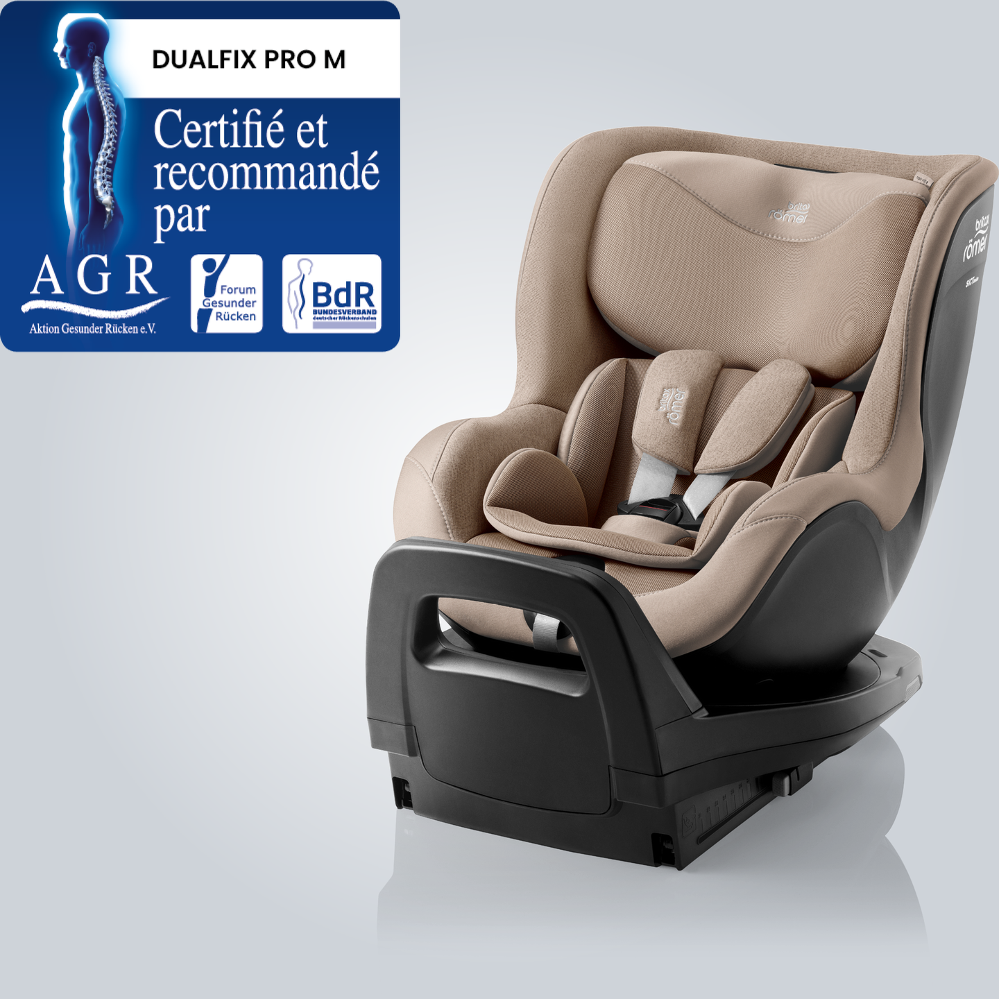 DUALFIX PRO M en Teak, si&egrave;ge auto pivotant &agrave; 360&deg; pour tout-petit avec appuie-t&ecirc;te et syst&egrave;me de harnais r&eacute;glables, pr&eacute;sent&eacute; en vue avant inclin&eacute;e avec le badge &laquo; Tested & Recommended &raquo; de Aktion Gesunder R&uuml;cken e.V.
