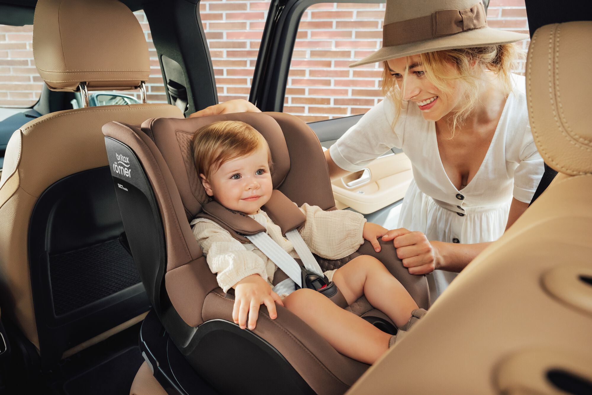 Tout-petit installé dans un siège auto DUALFIX 5Z toddler car seat, avec sa mère à ses côtés.