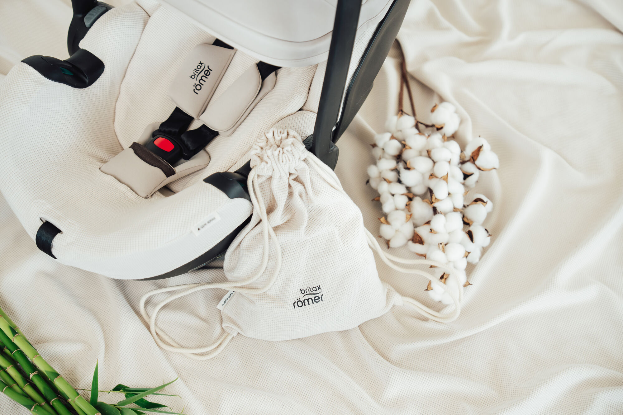 Housse d’été BABY-SAFE PRO sur un siège auto pour bébé, avec tissu respirant, sac à cordon assorti et accents en coton doux.